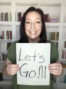 Picture of Heather holding "Let's go" sign